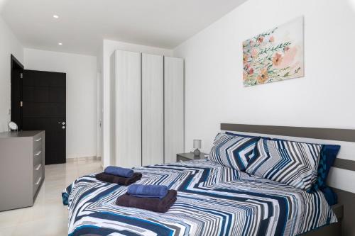 a bedroom with a bed with two towels on it at Modern 3BR Stylish Apartment with large Balcony - Close to St Julians and St Georges Bay in Is-Swieqi