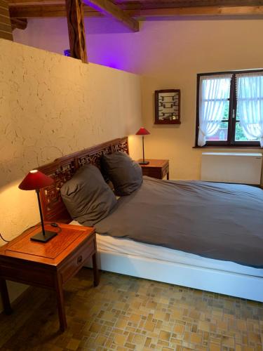 um quarto com uma cama e uma mesa com um candeeiro em Trusties em Dirbach