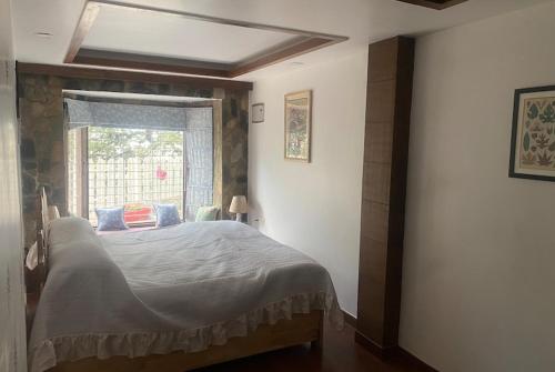 a bedroom with a large bed with a window at 2BHK Apartment In Mansion Near Nainital Lake in Nainital