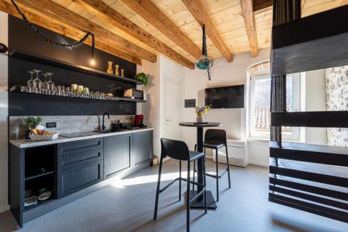 eine Küche mit schwarzen Schränken und eine Bar mit Hockern in der Unterkunft Una Rosa sul Mincio in Valeggio sul Mincio
