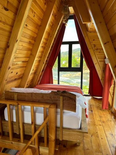 1 dormitorio en una cabaña de madera con una ventana grande en Yeşil Düş Tatil Köyü, en Fındıklı
