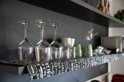 a shelf with wine glasses and cups on it at Una Rosa sul Mincio in Valeggio sul Mincio