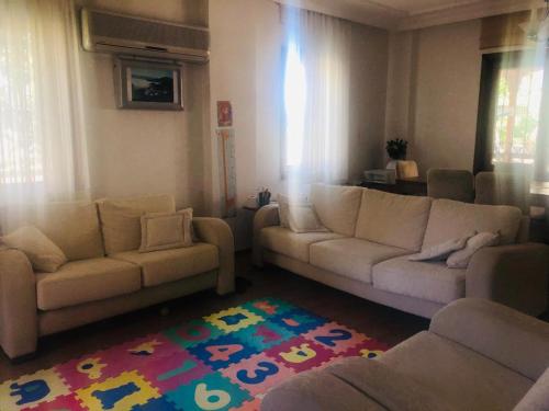 een woonkamer met 2 banken en een tapijt bij Yazlık in Burhaniye
