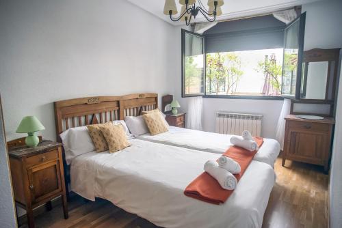 a bedroom with two beds and a window at UN JARDIN EN LA CIUDAD gran piso y super terraza en el centro By Apartamentos con aire acondicionado Logroño in Logroño
