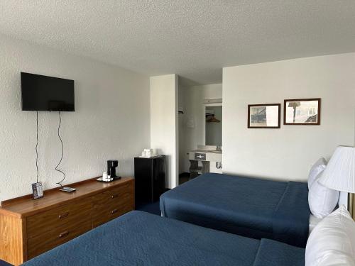 a hotel room with two beds and a flat screen tv at Bayside Inn in Saint Ignace