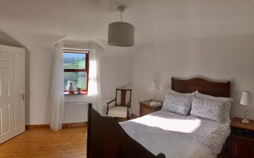 um quarto com uma cama grande e uma janela em Ballycastle Glenview House 4 bedrooms in the Glens of Antrim em Ballycastle