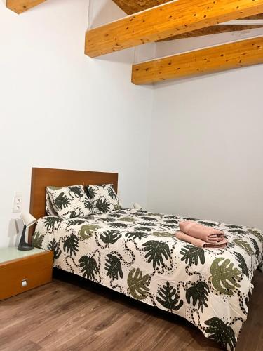 a bedroom with a bed with a black and white comforter at La Caseta del Fai in Riells del Fay