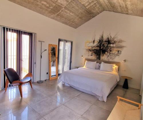 a bedroom with a white bed and a chair at OPUNTIA Hotel Boutique in Mijas