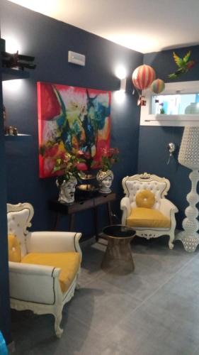 a room with two chairs and a painting on the wall at Boutique Hotel Ferrara in Ferrara