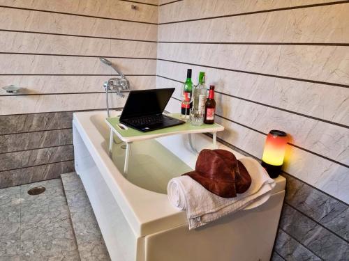 a laptop computer sitting on top of a bath tub at The Bunker Burwa Manali in Manāli