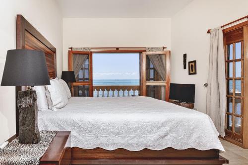 a bedroom with a bed and a large window at Hol Chan Reef Resort & Villas in San Pedro