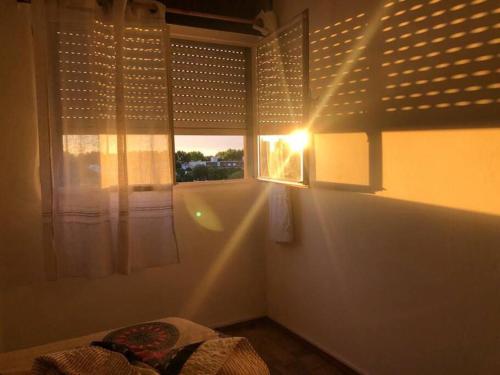 a bedroom with a window with the sun shining through at Cómodo apartamento en Colonia, cerca de todo in Colonia del Sacramento