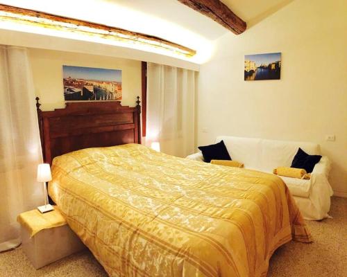 a bedroom with a large bed and a couch at Ca' Spendore del Sole in Venice