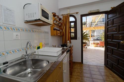 a kitchen with a sink and a microwave at Dolphins in Elounda
