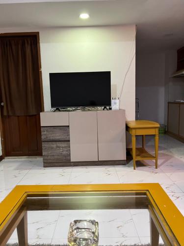 a living room with a tv and a table at Mall Suites Hotel in Bangkok