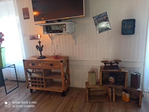 um quarto com mobiliário em madeira e uma televisão na parede em Les Gones en Vendée em Saint-Gervais