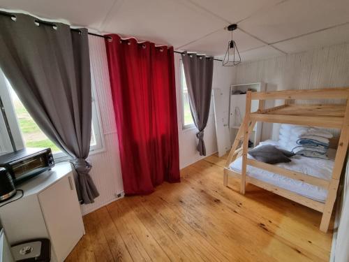 a bedroom with red curtains and a bunk bed at Domek Wakacyjny Patrycja 47 in Głębokie