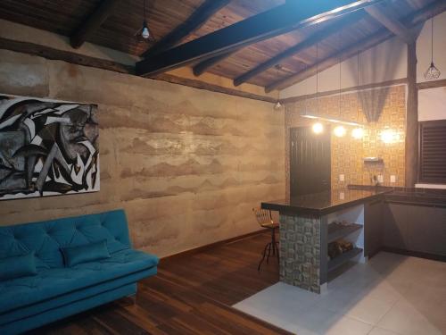 a living room with a blue couch and a table at Villa Taipas - Chalé Iepê in Cavalcante