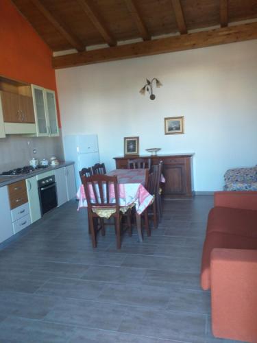 una cucina e una sala da pranzo con tavolo e sedie di Il Mandorleto a Cirò Marina