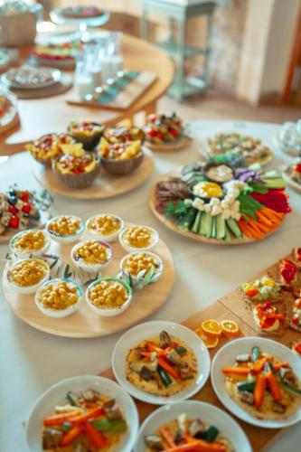 a table with many plates of food on it at Curolla Petit Hotel in Maria de la Salut