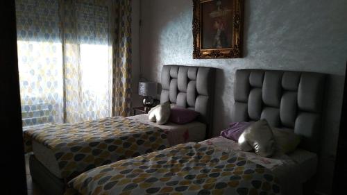 a bedroom with two beds and a headboard and a window at Villa avec piscine privée près de Casablanca Maroc in Dar Bouazza