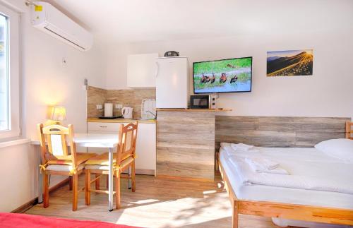 a bedroom with a table and a bed and a kitchen at New Studio with AirCon & FREE Parking in Ljubljana