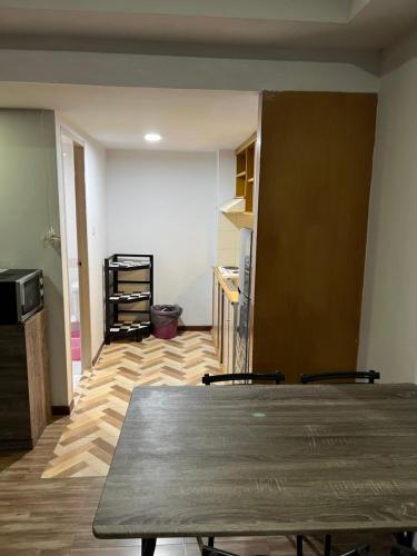 a living room with a table and a kitchen at Mall Suites Hotel in Bangkok