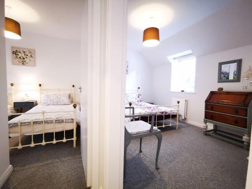 1 dormitorio con cama, escritorio y ventana en Rose Cottage en Conwy