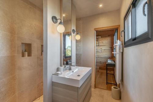 uma casa de banho com um lavatório branco e um chuveiro em Villa privée 12 personnes piscine chauffée - ARES em Arès