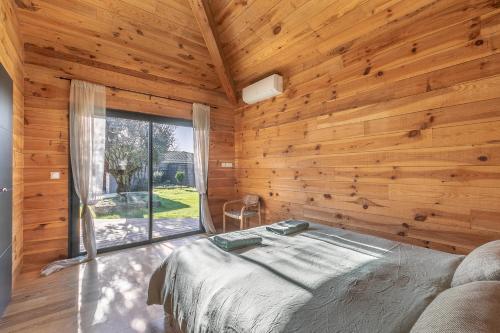 um quarto com uma cama e uma grande janela em Villa privée 12 personnes piscine chauffée - ARES em Arès
