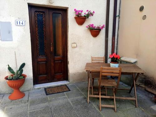 uma mesa de madeira e cadeiras em frente a uma porta em N. & A. Sweet Home em Lucca