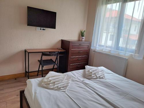 a bedroom with a bed and a desk and a television at Тиловите къщи in Ribarica