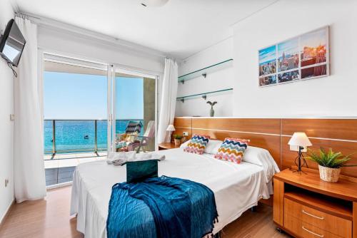 a bedroom with a bed and a large window at Apartment Barlovento 2 - PlusHolidays in Calpe