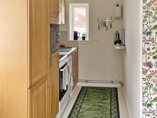 a small kitchen with a green rug on the floor at Holiday home GAGNEF in Gagnef