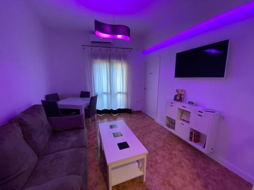 a living room with a couch and a table and purple lights at COSTASOL CORDOBA - Apartamento moderno - céntrico in Córdoba