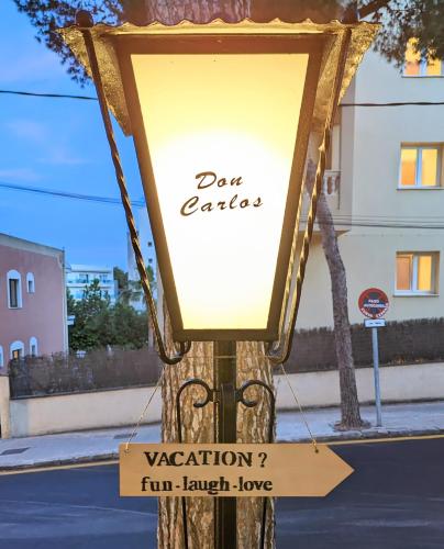a sign on a pole on a street at Don Carlos in Paguera