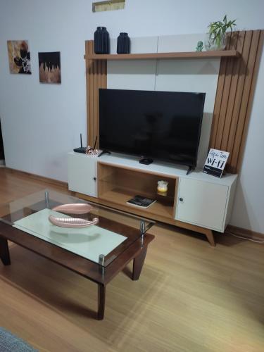 a living room with a tv and a coffee table at Apartamento confortavel Centro de Teresopolis. NOVO in Teresópolis