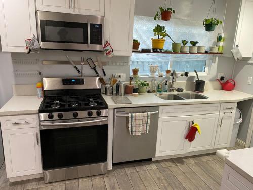 a kitchen with a stove and a microwave at Private Room in Los Angeles LA with TV & WIFI & AC & View of Hollywood Sign & Private Fridge & Shared Kitchen!!! in Los Angeles