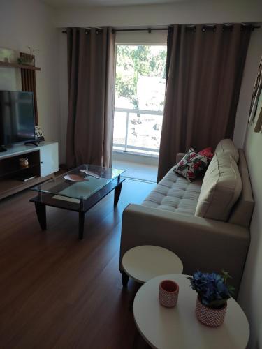 a living room with a couch and a coffee table at Apartamento confortavel Centro de Teresopolis. NOVO in Teresópolis