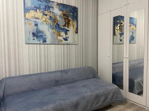 1 dormitorio con 1 cama y una pintura en la pared en Комфортабельные - уютные апартаменты в Костанай мкр Береке1, en Kostanái