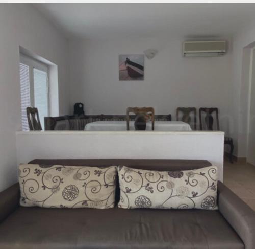 ein Sofa mit einem Kissen im Wohnzimmer in der Unterkunft Villa M in Neum