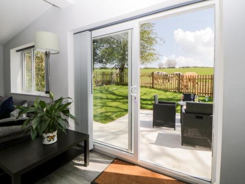 a living room with a sliding glass door leading to a patio at The Hideaway in Kingsbridge