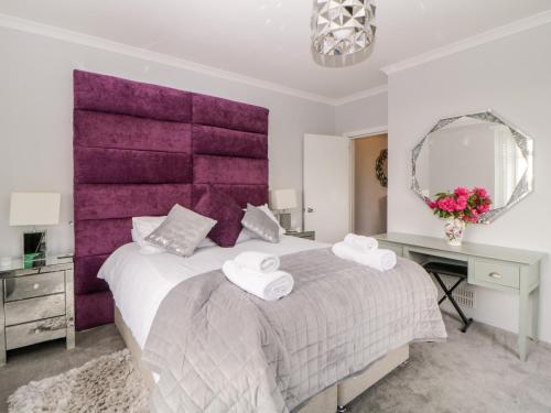 a bedroom with a purple headboard and a bed at The Hideaway in Kingsbridge