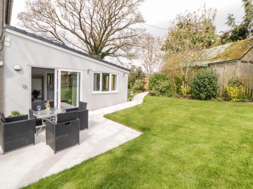 a small white house with a grass yard at The Hideaway in Kingsbridge