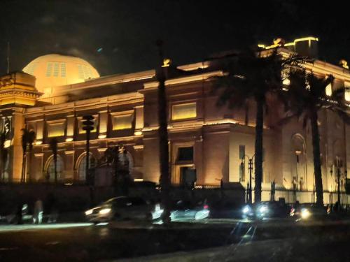 a building at night with a palm tree in front of it at One Season Hotel in Cairo