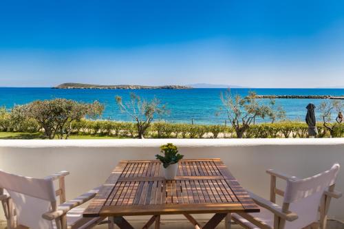 a table and chairs on a balcony with a view of the ocean at La Mer Seaside Apartments in Drios
