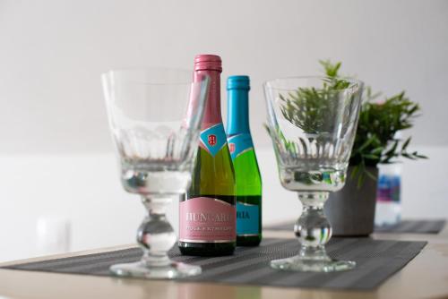 two bottles of wine and two glasses on a table at Valentin ház in Szentendre