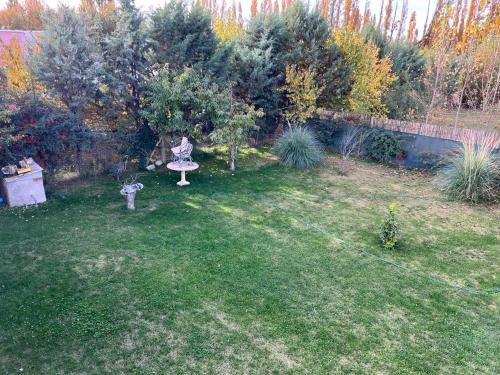 un jardín con una estatua en el césped en El mejor lugar Secreto en Plottier