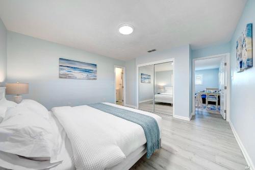- une chambre avec un lit blanc et une salle à manger dans l'établissement 7308 Sunset B by Nautical Properties Vacation Rentals, à Panama City Beach