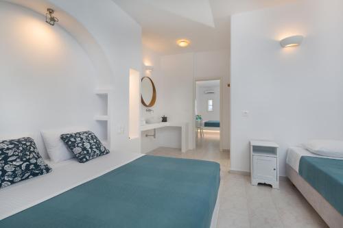 a white bedroom with a bed and a bathroom at La Mer Seaside Apartments in Drios